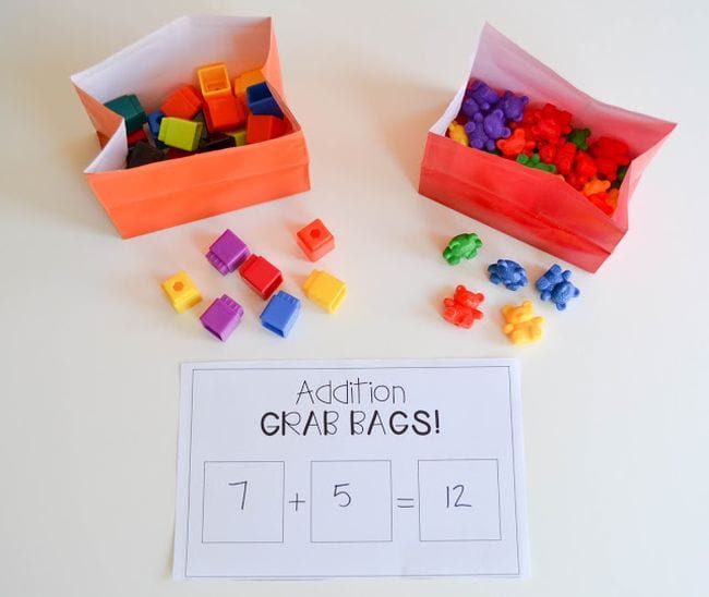 Bolsas de papel coloridas llenas de cubos de matemáticas y osos de plástico, y una hoja de trabajo llamada Bolsas de agarre adicionales (juego de matemáticas de primer grado)