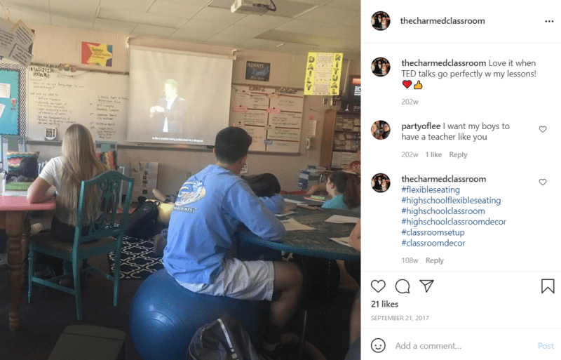 Los estudiantes en el salón de clases se sientan en una variedad de asientos, como pelotas de yoga, bolsas de frijoles y sillas de comedor, y miran charlas de Ted en pantallas de proyección.